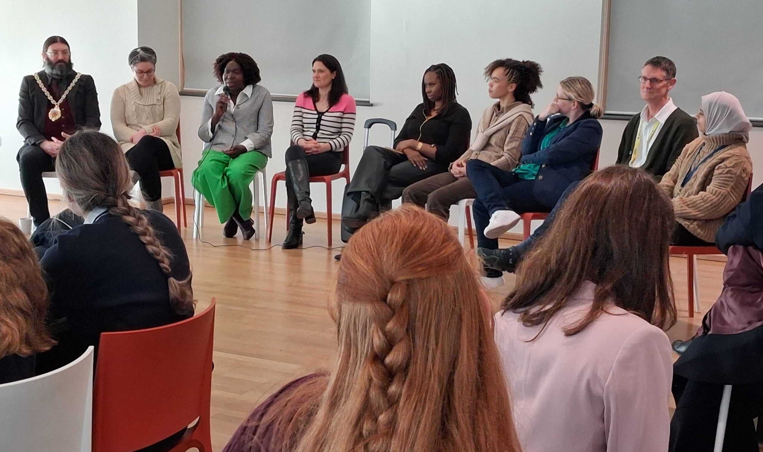 Row of people sat in a line talking at an event